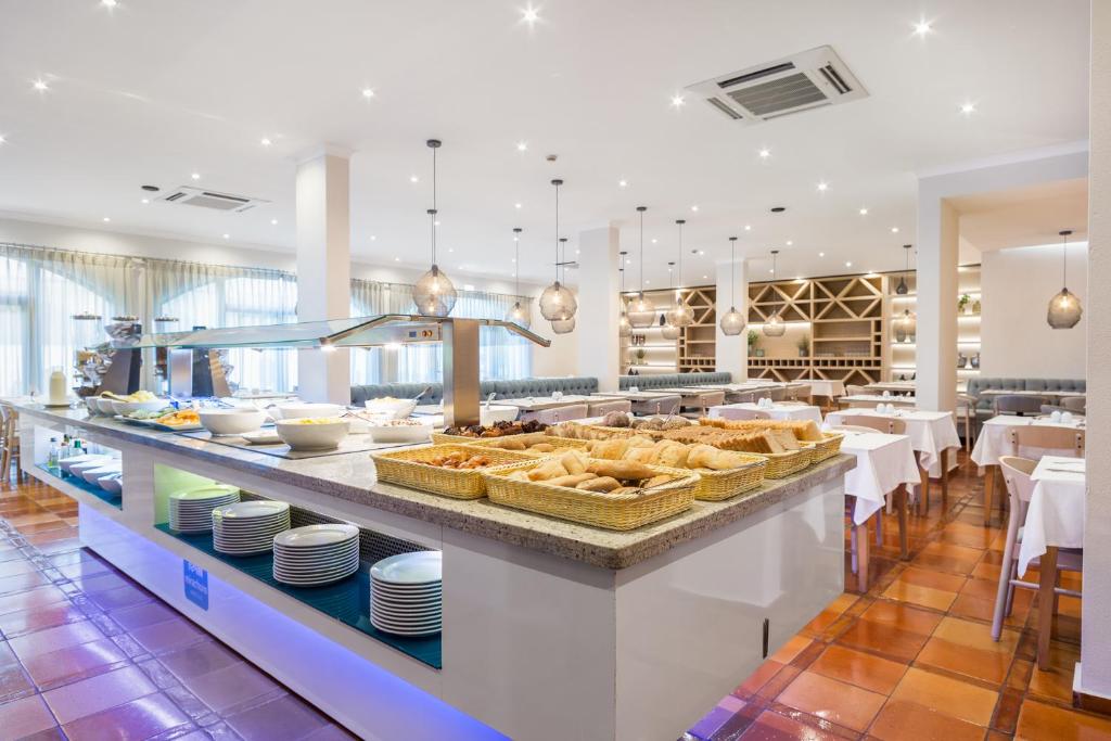 a buffet line with baskets of bread and dishes at Mirachoro Carvoeiro in Carvoeiro