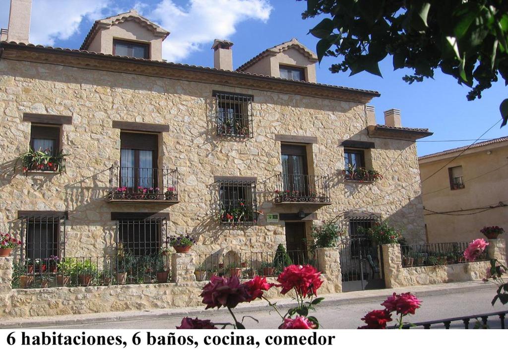 un edificio de piedra con flores delante en Casa rural Marcelina, en Beteta