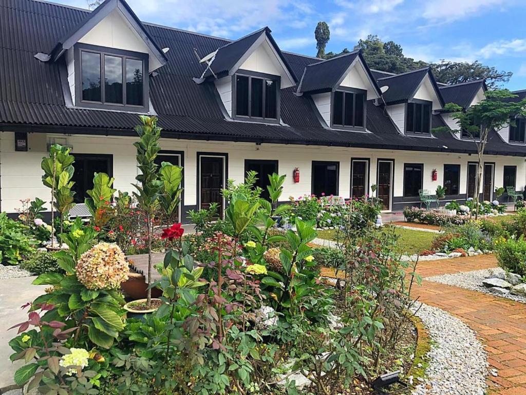 a house with a lot of flowers in front of it at Tiny Boutique Habitat in Tanah Rata