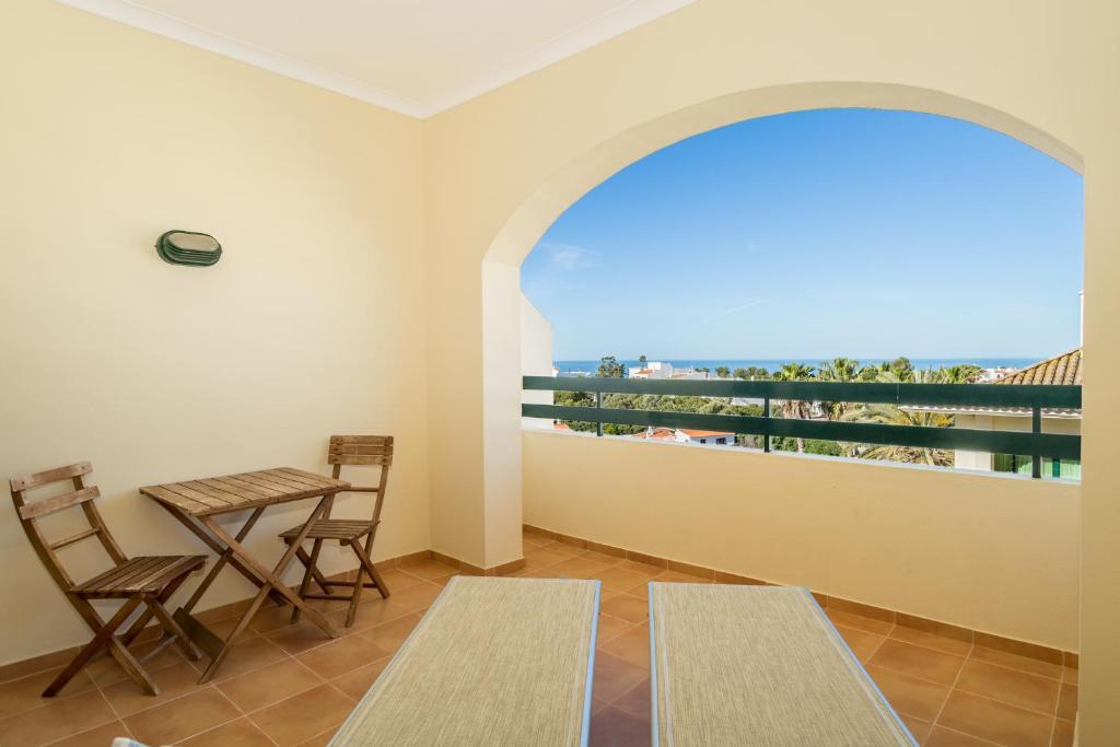 a room with a balcony with a table and chairs at Mirachoro Carvoeiro in Carvoeiro