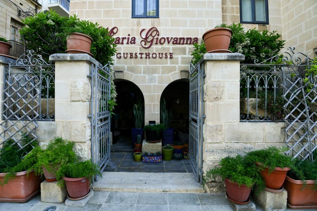 Zugang zu einem Gebäude mit Topfpflanzen in der Unterkunft Maria Giovanna Guest House in Marsalforn