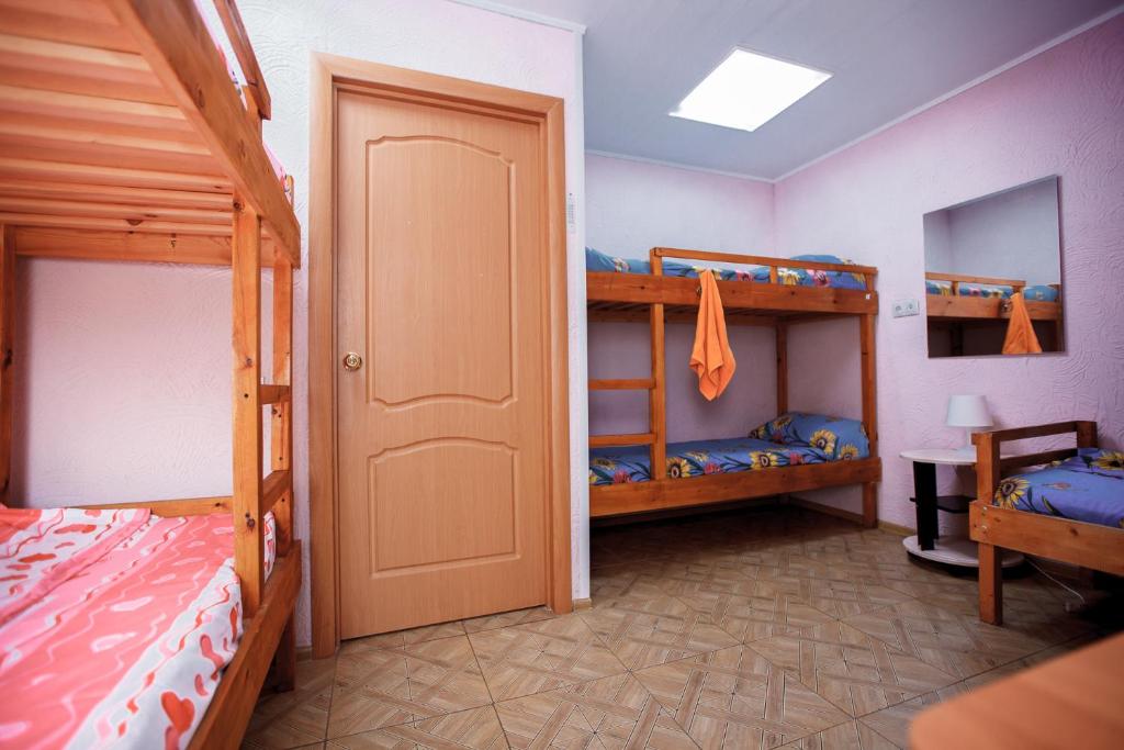 オムスクにあるГостевой дом АГАТの二段ベッド2台とドアが備わる客室です。