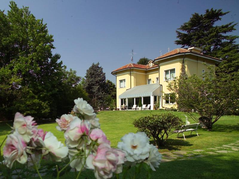 una gran casa amarilla con flores delante en Villa La Maggiorana, en Rivoli