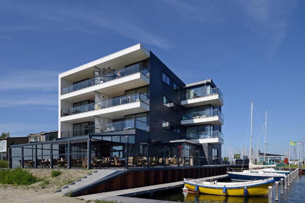 a building with boats in the water in front of it at Veerse Muze in Kamperland