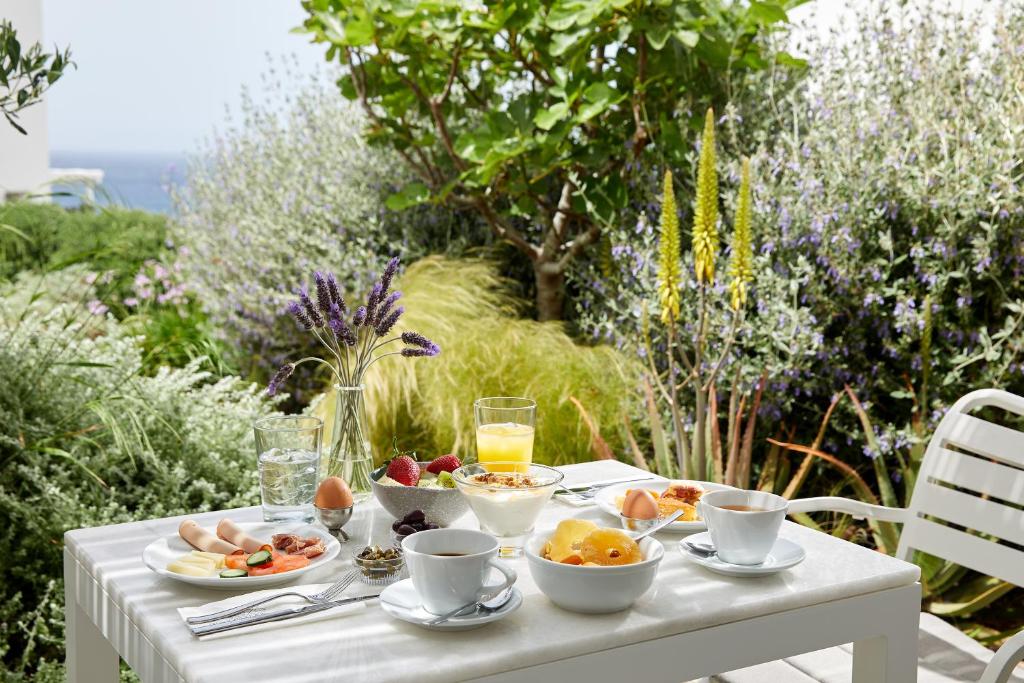 a white table with food and drinks on it at Milos Breeze Boutique Hotel in Pollonia