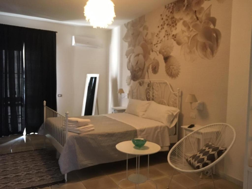 1 dormitorio con cama, mesa y lámpara de araña en La Villetta B&B, en Scisciano