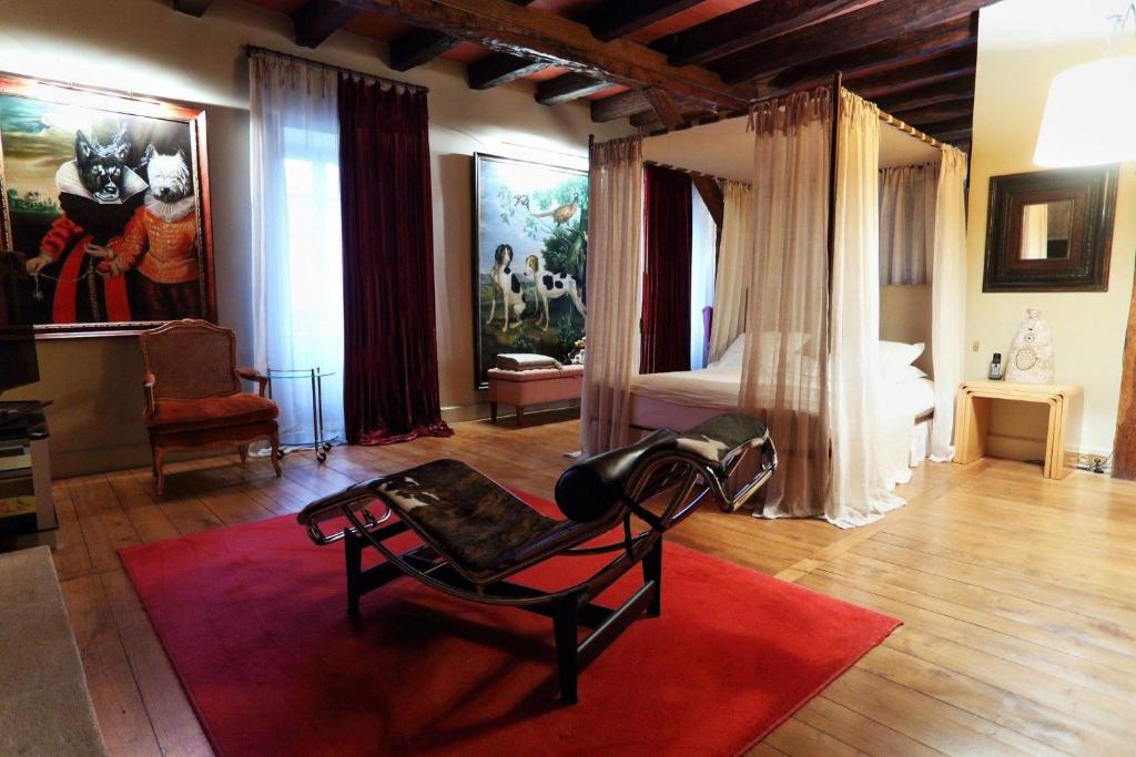 sala de estar con cama y alfombra roja en La Maison d'Alice, en Vézac