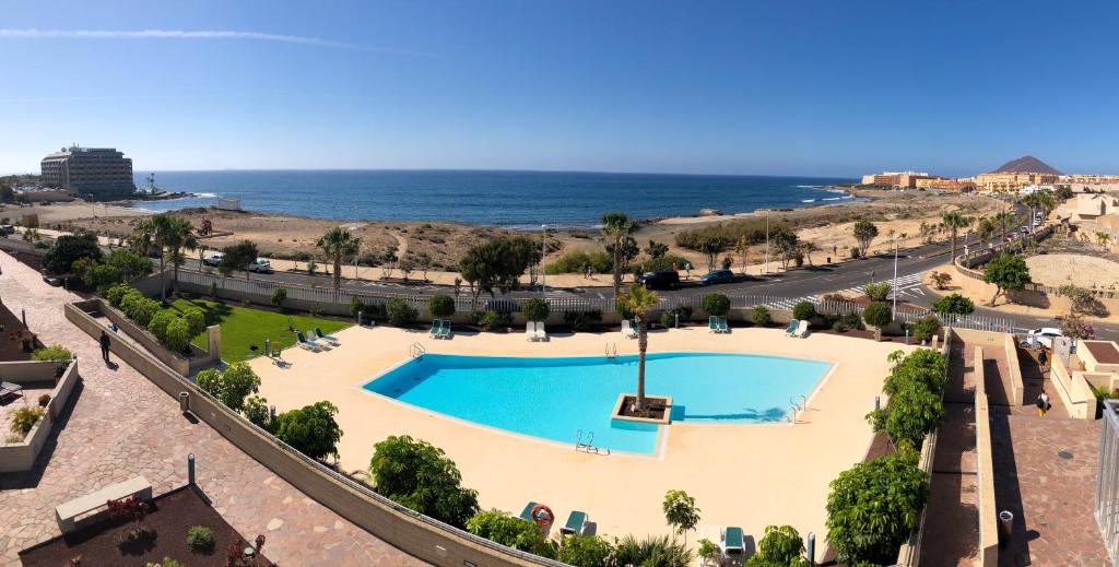 a swimming pool with the ocean in the background at Casa Bonita Médano in El Médano