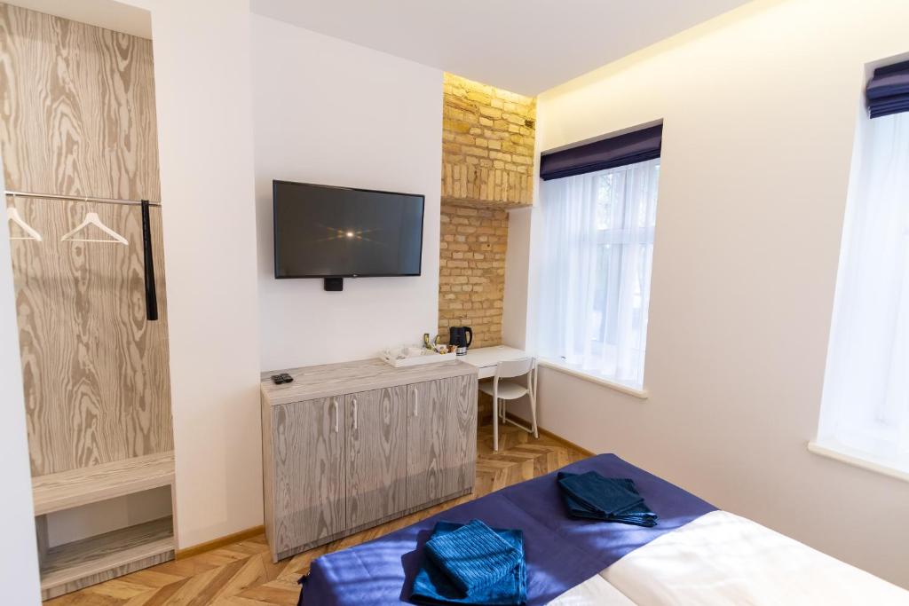 a bedroom with a bed and a tv on the wall at Hot Spot Vilnius Apartments in Vilnius