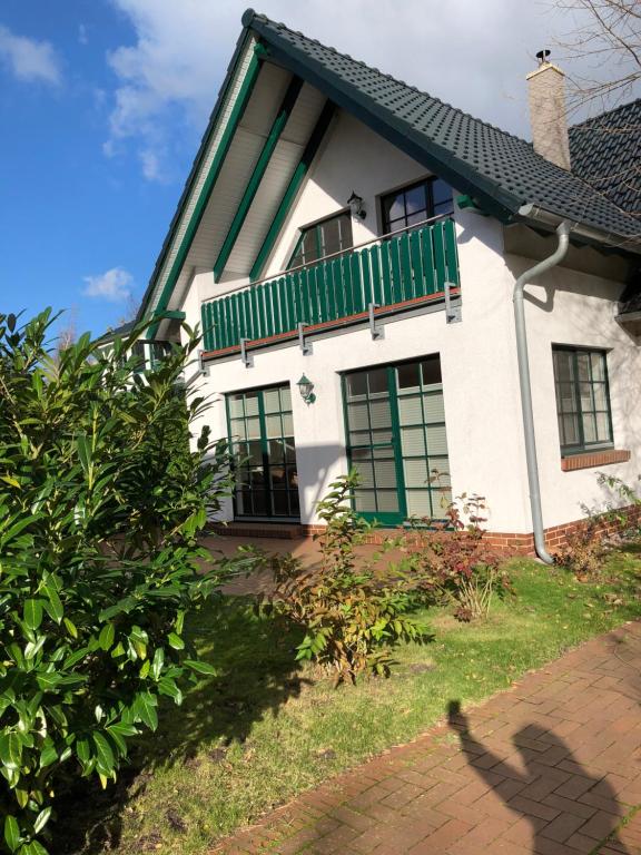 a house with a green balcony on top of it at Zingst Haus Hugo in Zingst