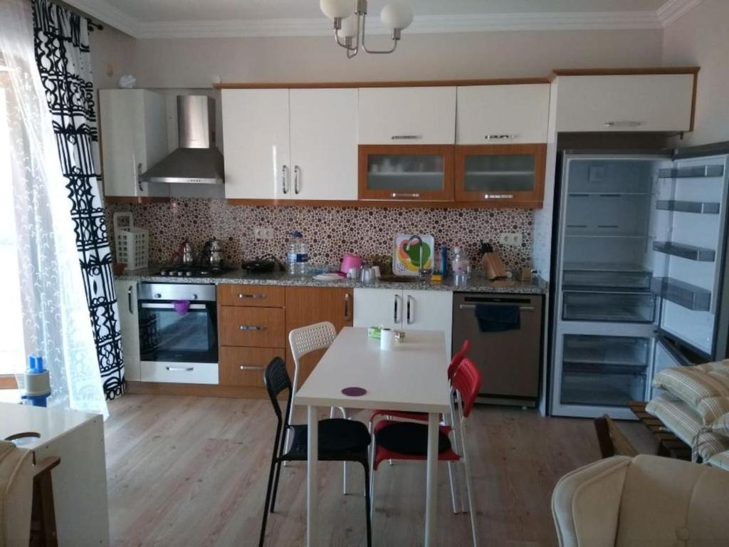 eine Küche mit einem Tisch und Stühlen im Zimmer in der Unterkunft İmbros House in the heart of the nature in Gokceada Town