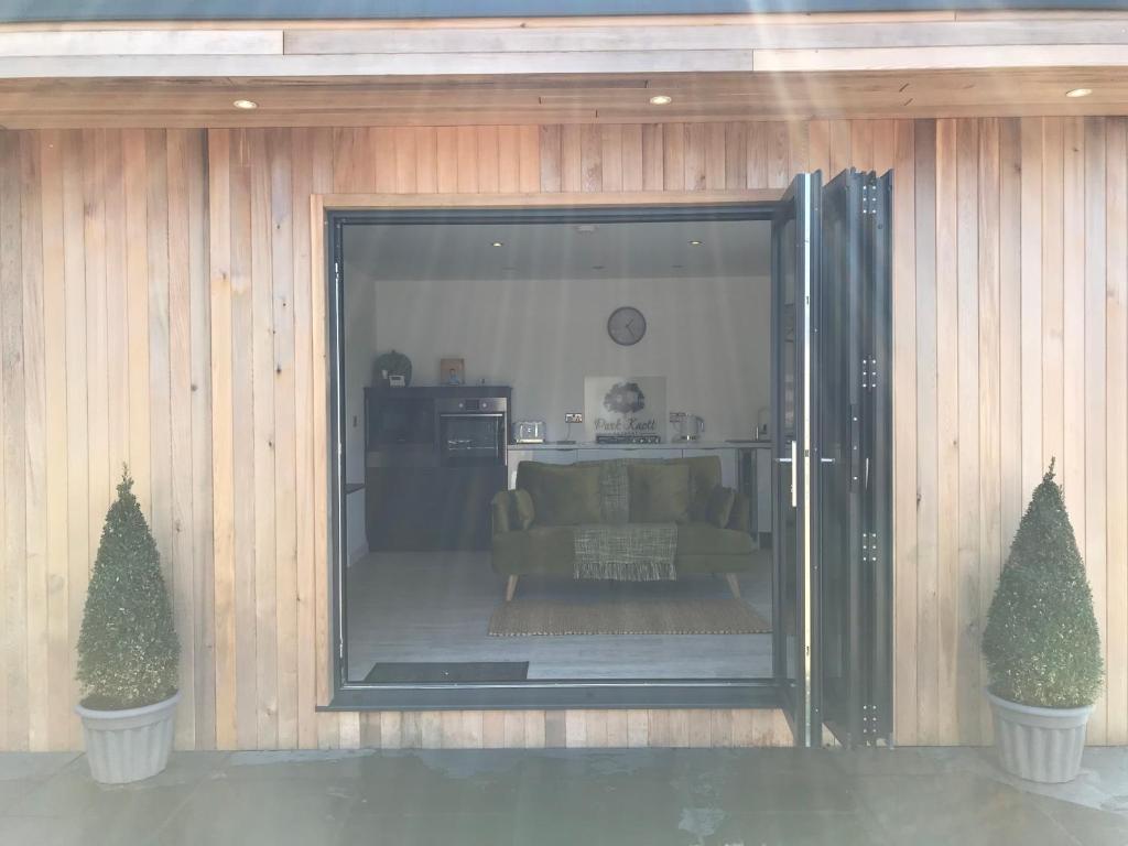 a living room with a couch and two trees at Parkknott Retreat Luxury Lodge with Private Hot Tub in Askam in Furness
