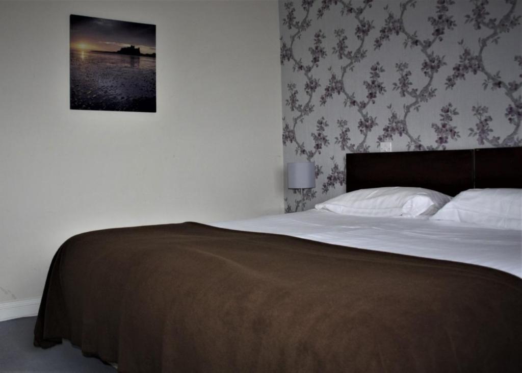 a bedroom with a bed with a picture on the wall at The Gandon Inn in Emo