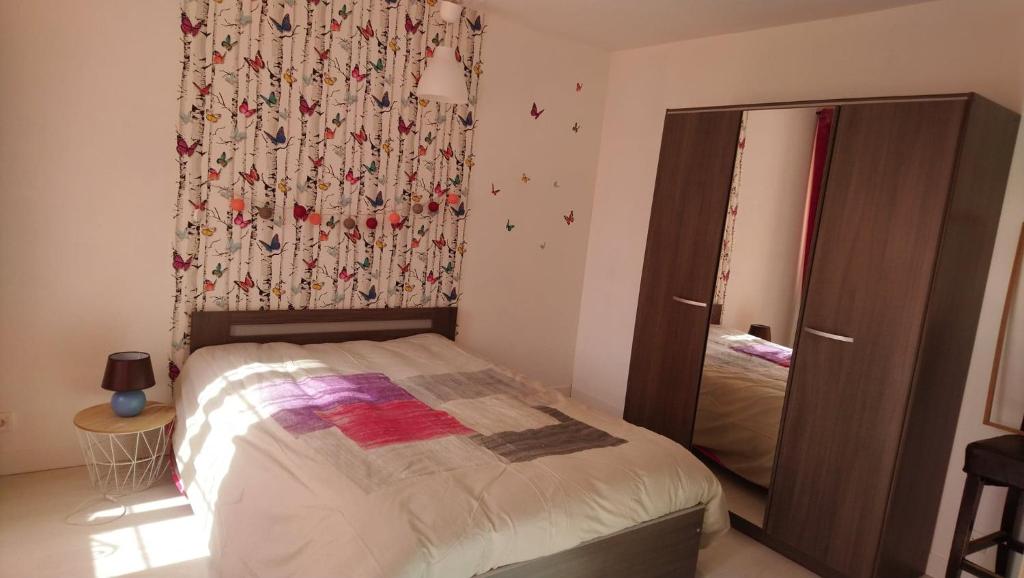 Dormitorio pequeño con cama y espejo en Gite pour 6 ou chambre pour 2 à FORMIGNY, en Formigny