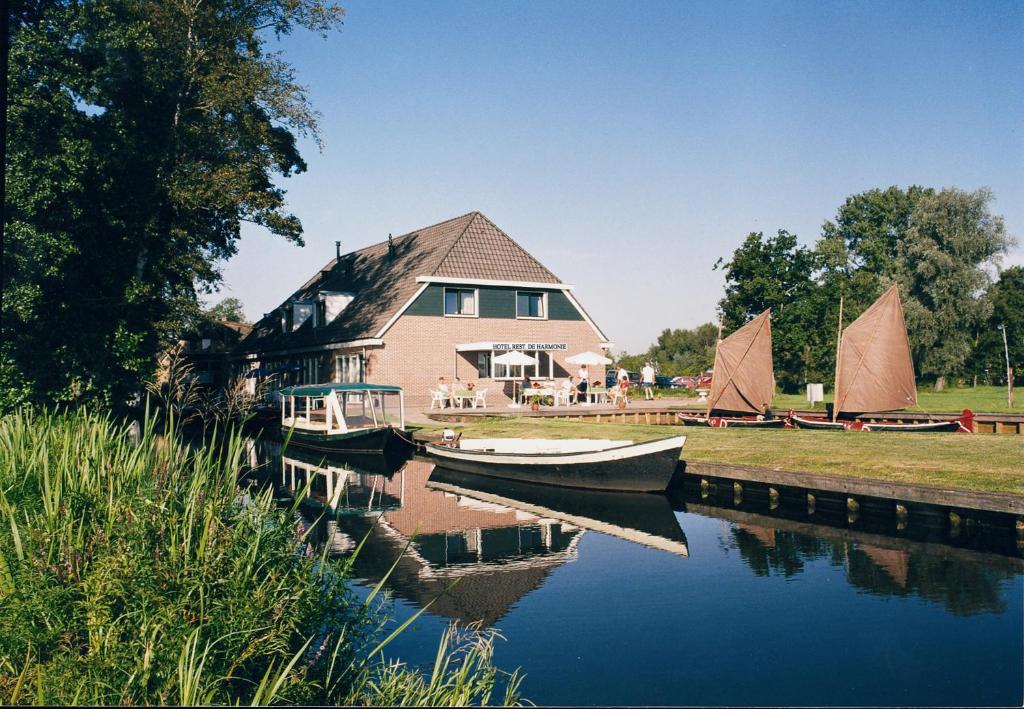 a large body of water with houses and boats at Hotel de Harmonie in Giethoorn