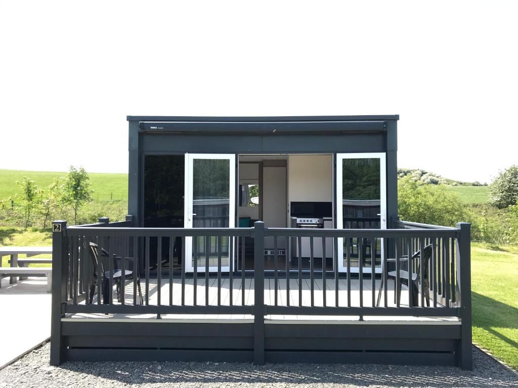 a screened in porch of a house with chairs at Parkknott Retreat in Askam in Furness