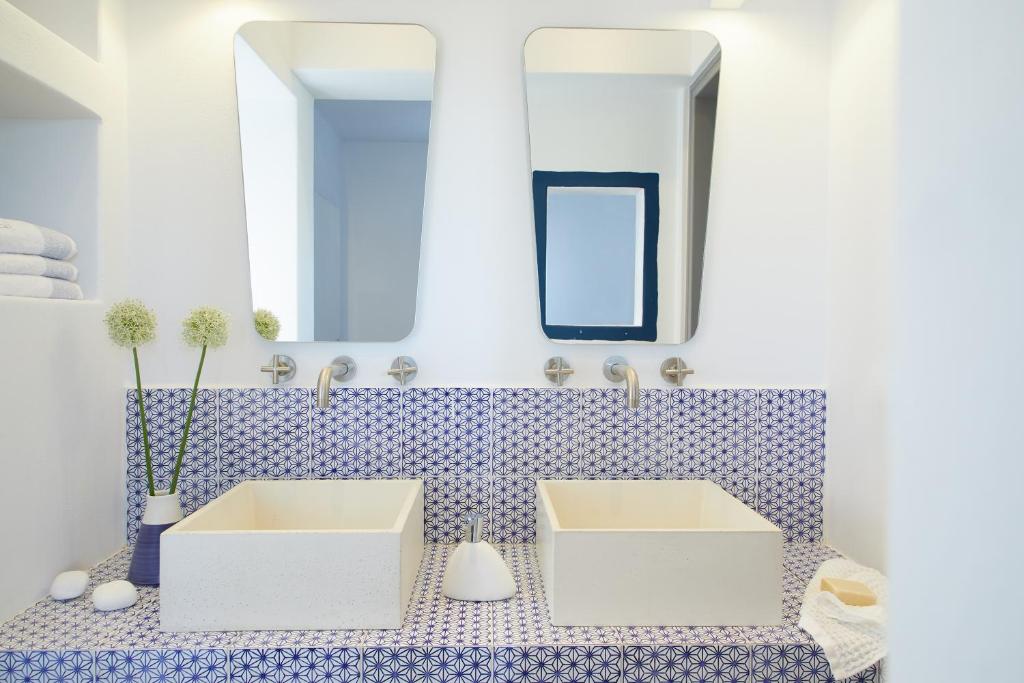 a bathroom with two sinks and a mirror at Milos Breeze Boutique Hotel in Pollonia