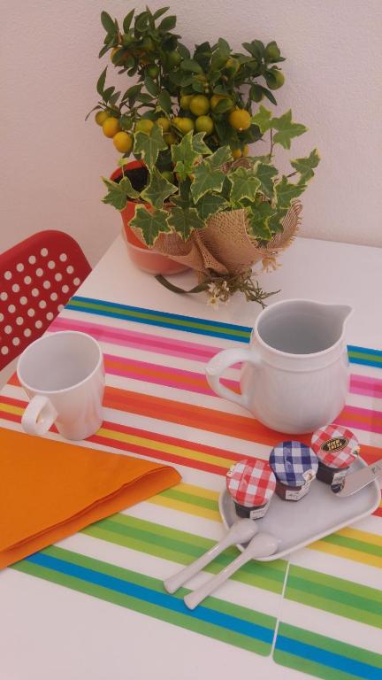 a table with two cups and spoons and a plant at La Dolce Vita studio with free private parking in Siena