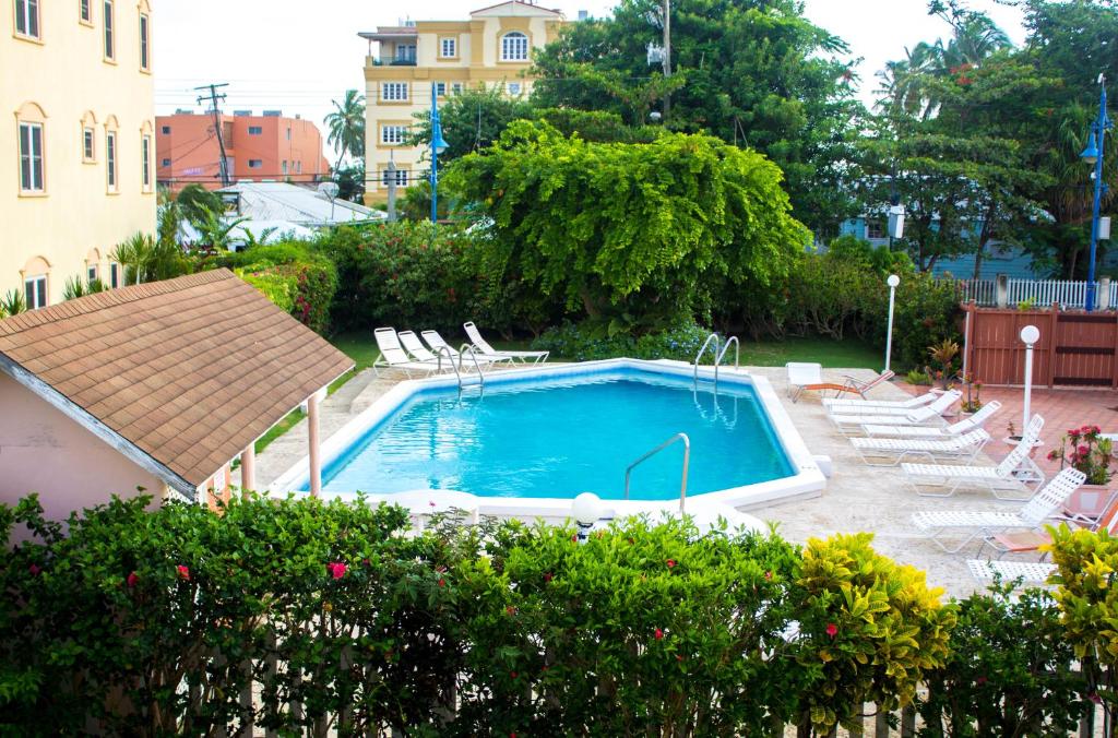 a swimming pool in a yard with lounge chairs at The Monteray Hotel in Christ Church