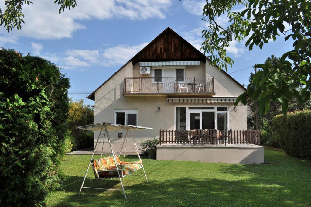 una casa con un columpio delante de ella en ZÁMOR HOLIDAY HOUSE en Keszthely