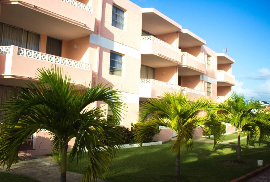 a building with palm trees in front of it at The Monteray Hotel in Christ Church