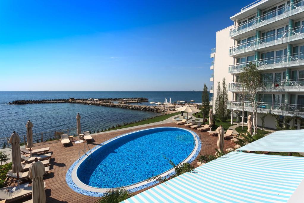 a swimming pool next to a building and the ocean at Carmen International Hotel Venus - Fost Becali Hotel in Venus