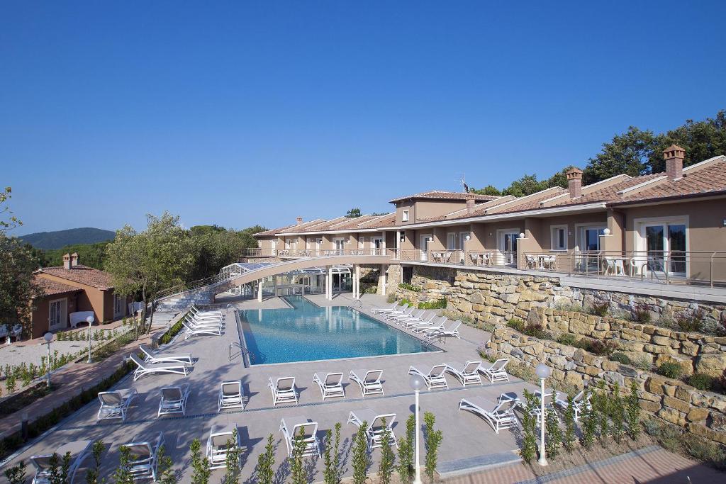 a resort with a swimming pool with chairs and a bridge at Relais I Piastroni in Monteverdi Marittimo