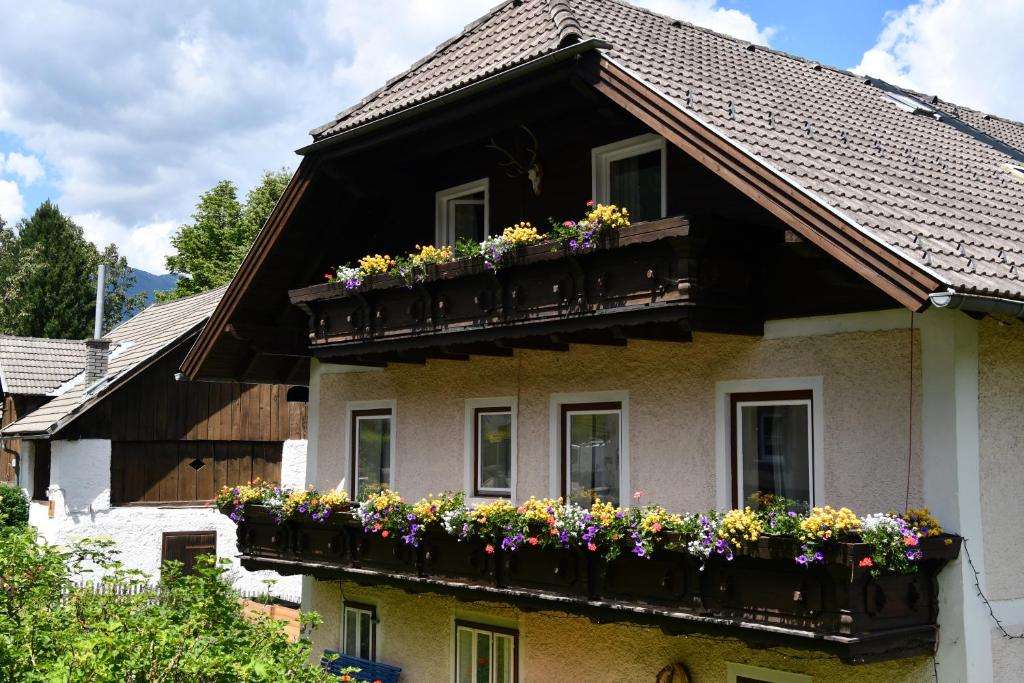 ein Haus mit Blumenkästen auf dem Balkon in der Unterkunft Gasthaus Chalet Mur in Sankt Michael im Lungau