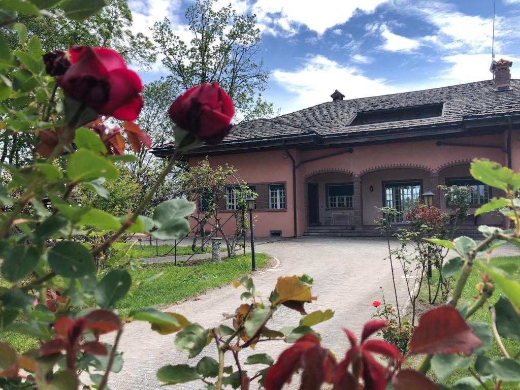 widok na dom z czerwonymi różami w obiekcie Villa Bonelli Bed & Fest w mieście Savigliano