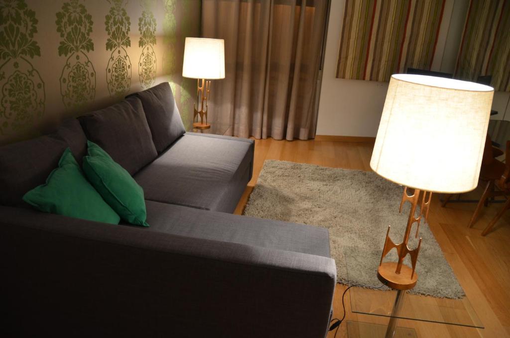 a living room with a couch and a lamp at The Green House in Lisbon