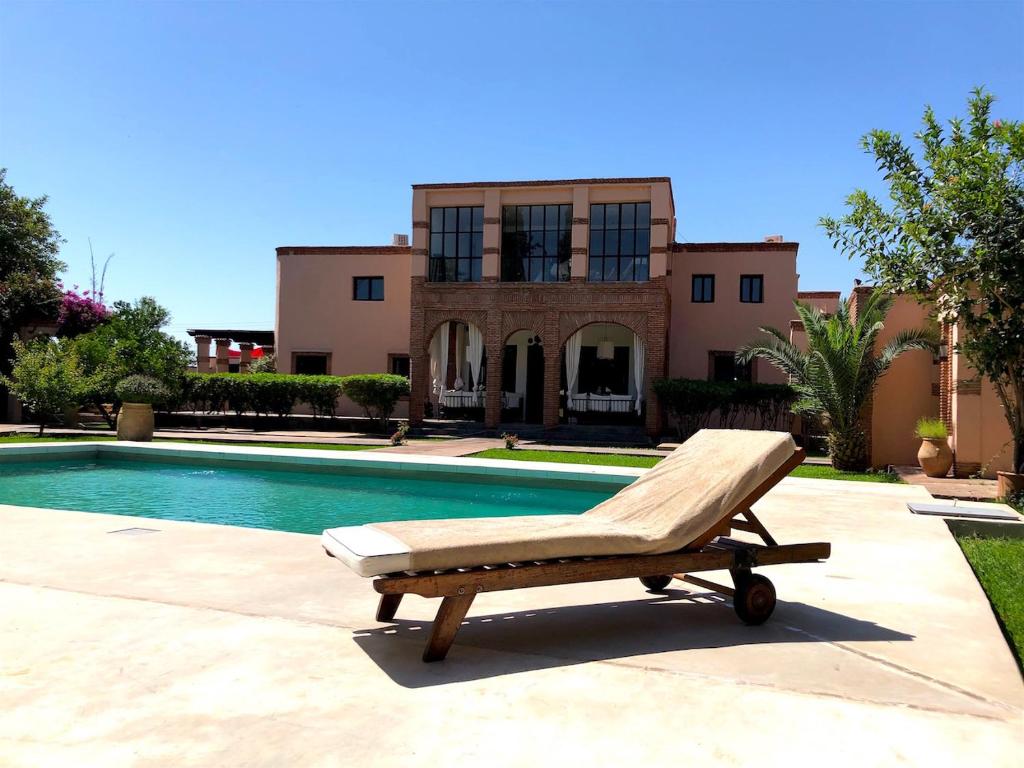 un sillón sentado frente a una piscina en Palais Souad, en Marrakech