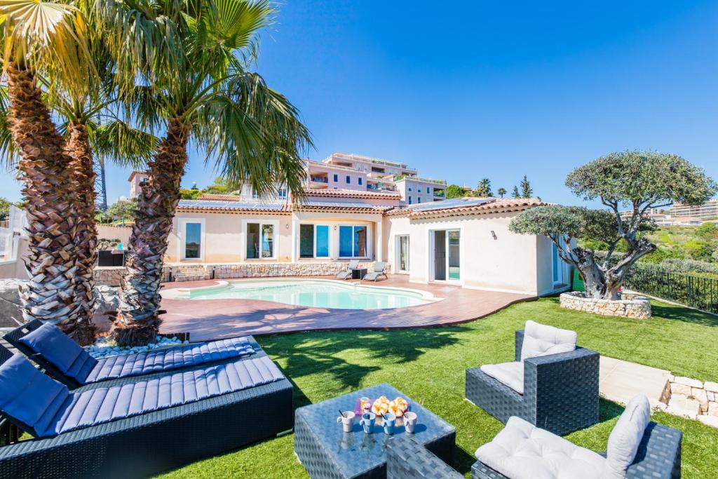een villa met een zwembad en palmbomen bij CORNICHE D'ARGENT - Nice in Nice