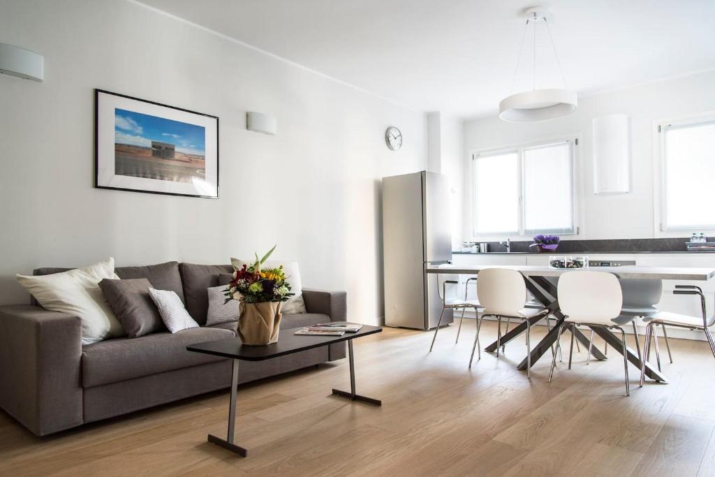 un soggiorno con divano e tavolo di Brand new apt , City Life district a Milano