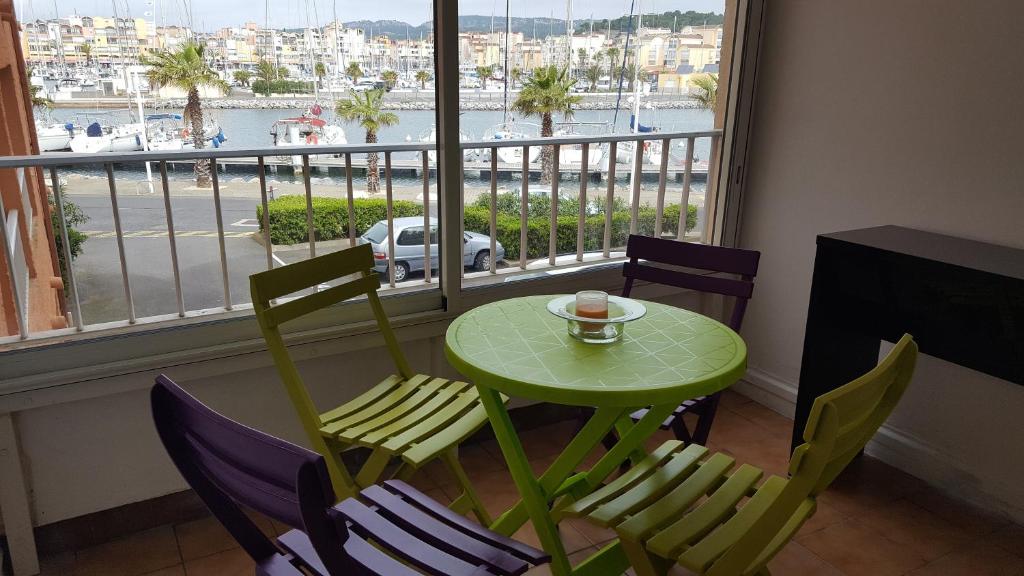 een tafel en stoelen met een kopje koffie en een raam bij T2 in Gruissan