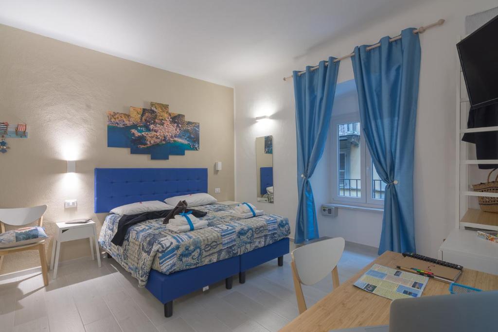 Un dormitorio con una cama azul y una mesa en Ca' da Sirio en La Spezia