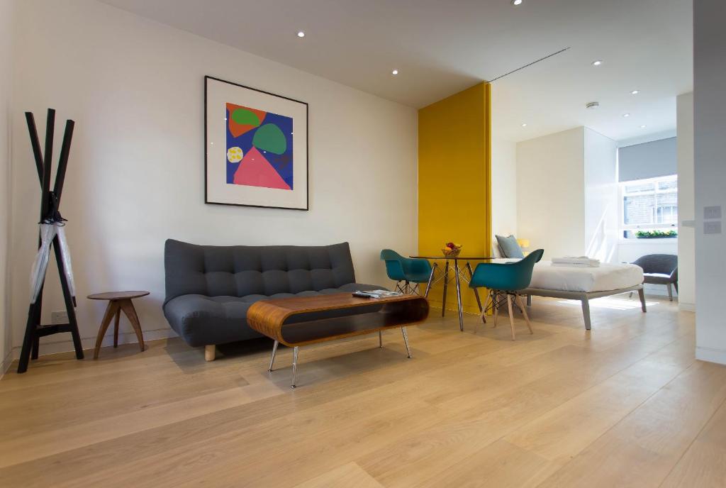 a living room with a couch and a table at NoHo 132 Serviced Apartments by Concept Apartments in London