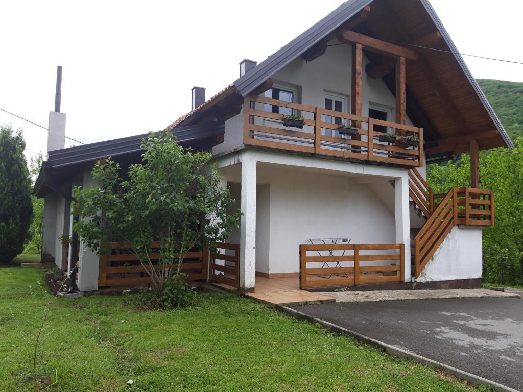 a house with a porch and a deck at Apartment Sanja in Smoljanac