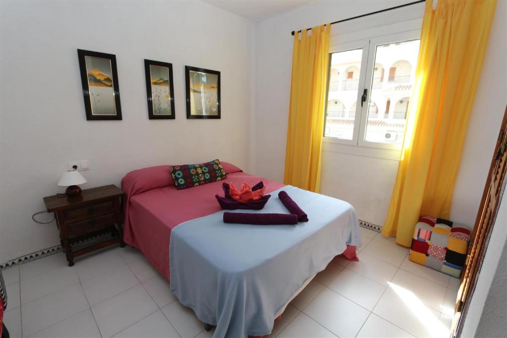 1 dormitorio con cama y ventana en Apartment overlooking to the pool 2450, en La Mata