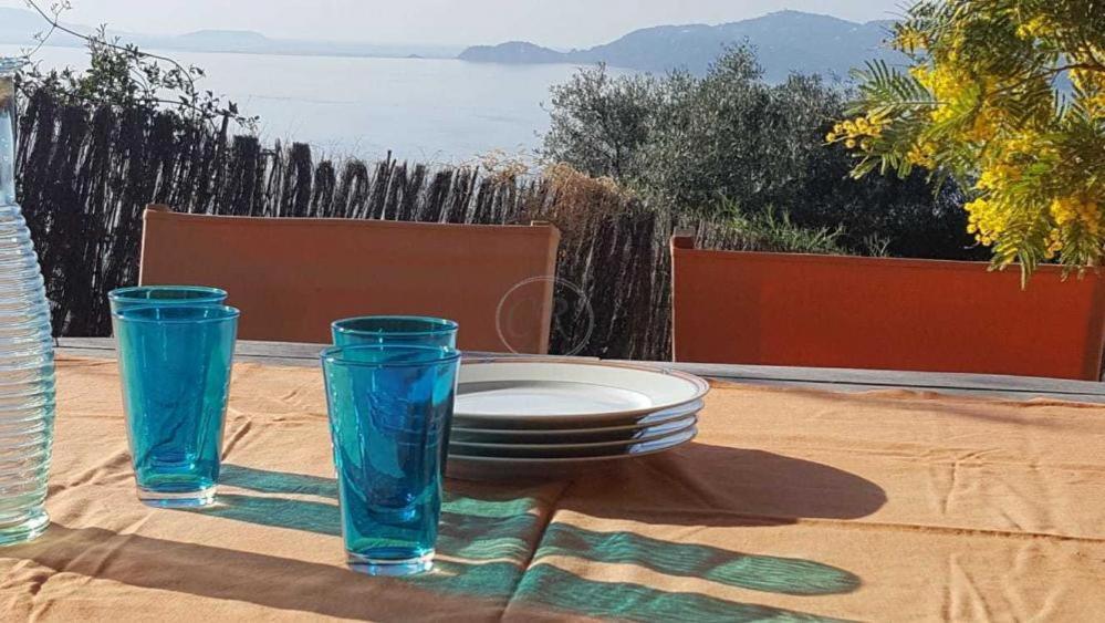 une table avec deux verres bleus et une plaque sur elle dans l'établissement T2 standing 800m de la plage de St Clair, au Lavandou