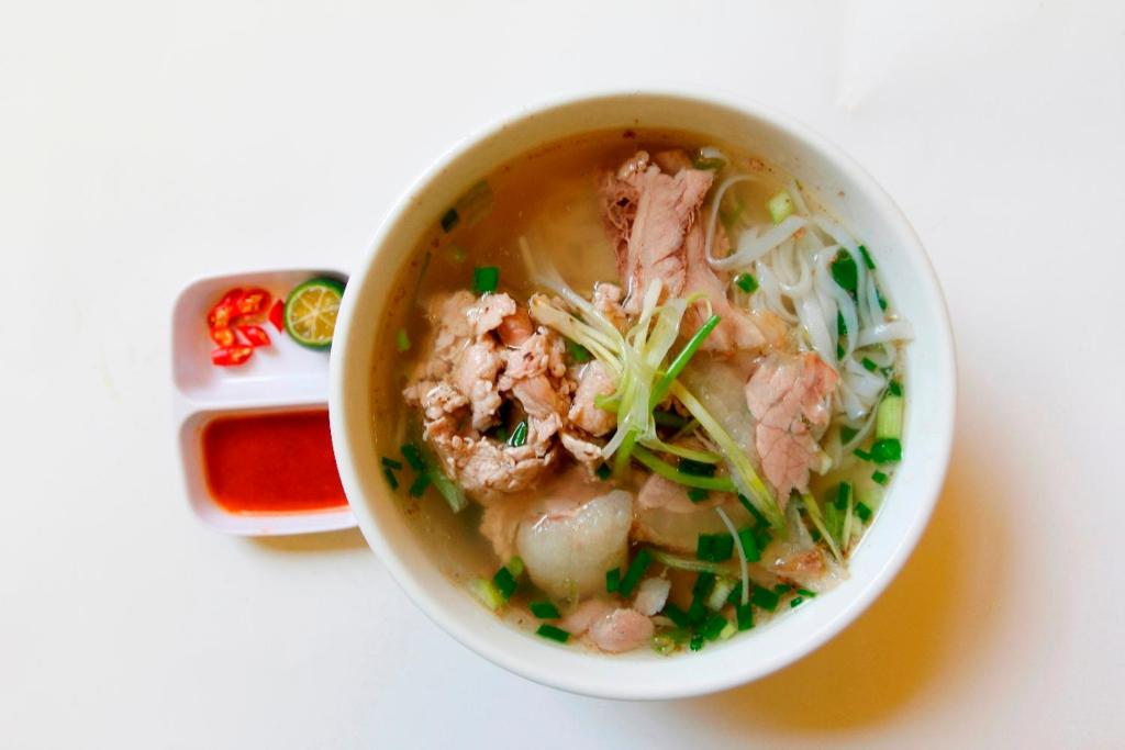 eine Schüssel Suppe mit Fleisch und Gemüse darin in der Unterkunft KHÁCH SẠN NGỌC LY 2 in Thanh Hóa