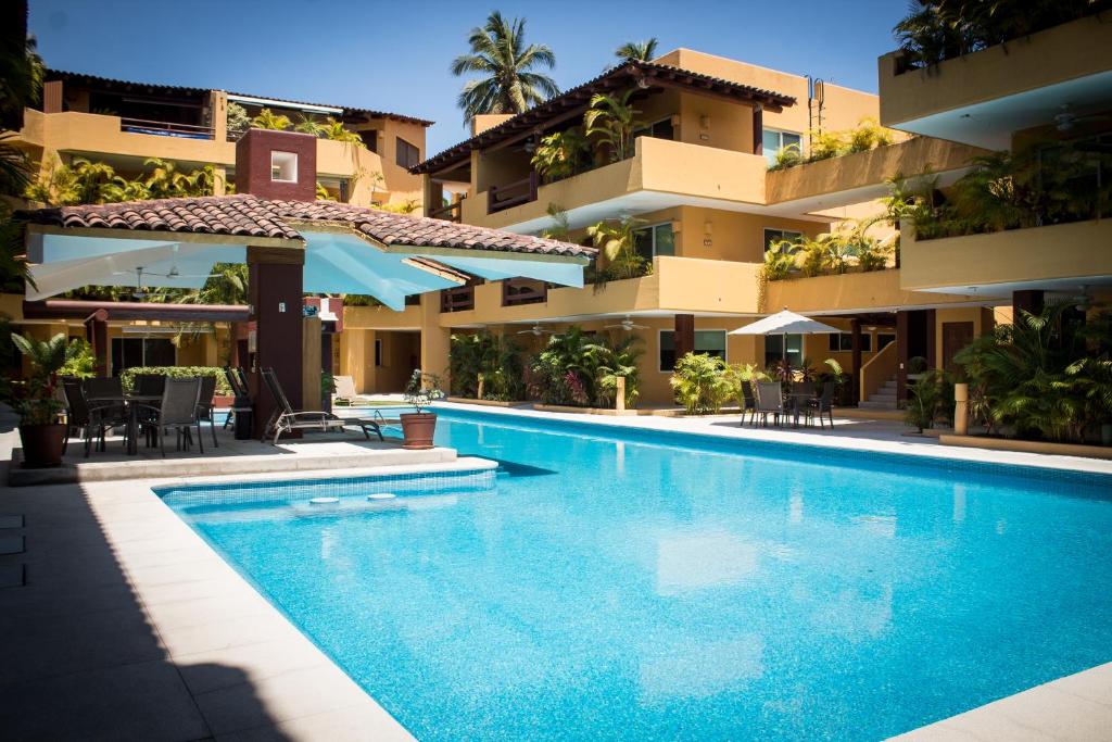 a swimming pool in front of a building at Los Mangos in Zihuatanejo