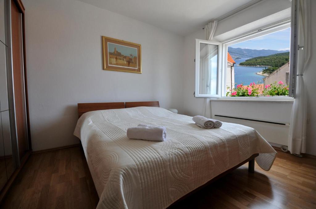 um quarto com uma cama e uma grande janela em Bella Vita em Korčula