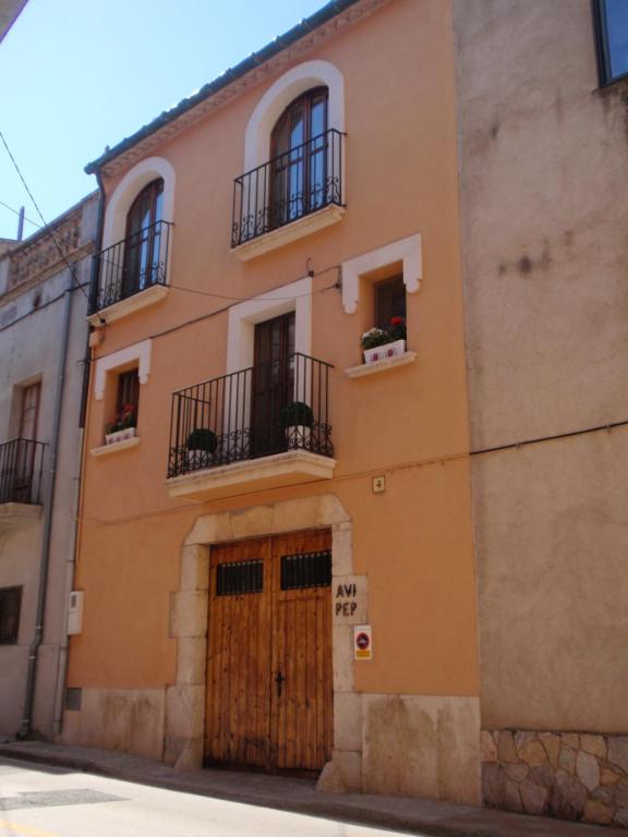 an orange building with two balconies and a wooden door at AVI PEP in Vilafant