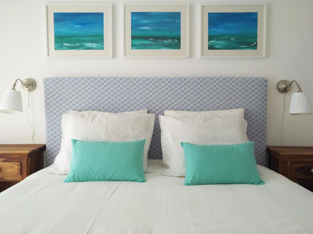 um quarto com uma cama com duas almofadas azuis e brancas em IM On Luz Arte em Luz