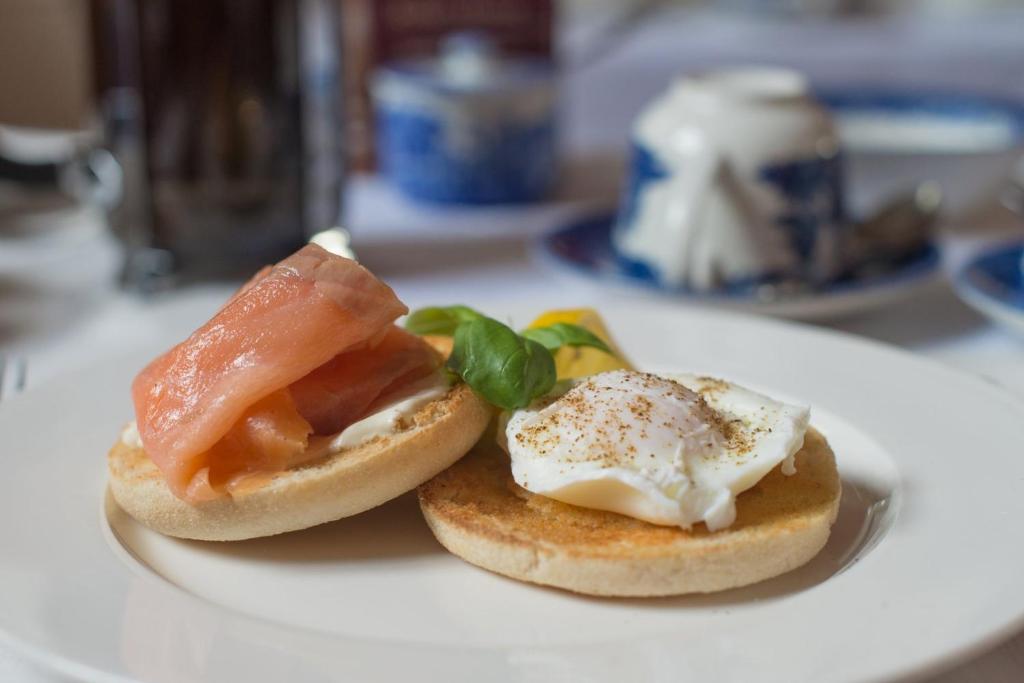 a white plate with two sandwiches on a table at Jeakes House in Rye