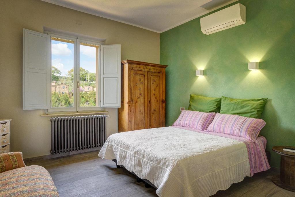a bedroom with a bed and a window at Podere Fontecastello in Montepulciano