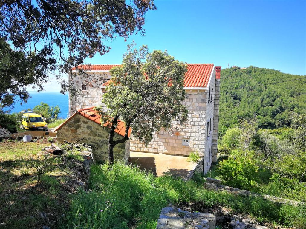 una casa de piedra con techo rojo en Countryside Vacation House VITEZ en Babino Polje