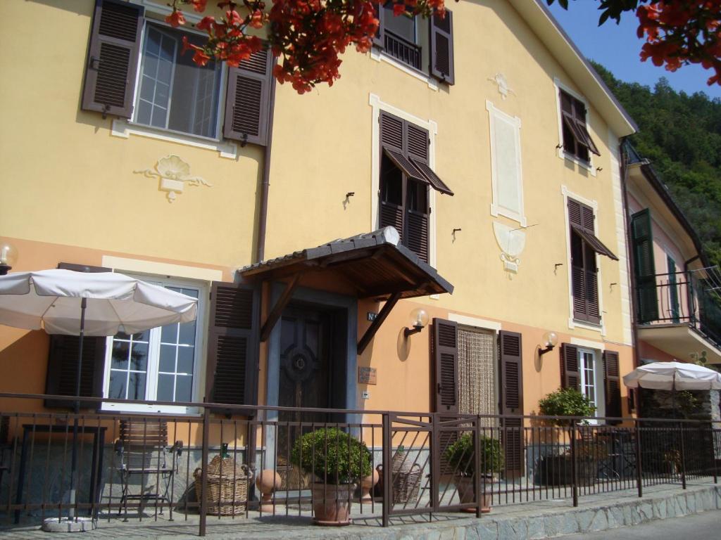 ein gelbes Gebäude mit schwarzen Rollläden und einem Balkon in der Unterkunft B&B Bella Vista in Paggi