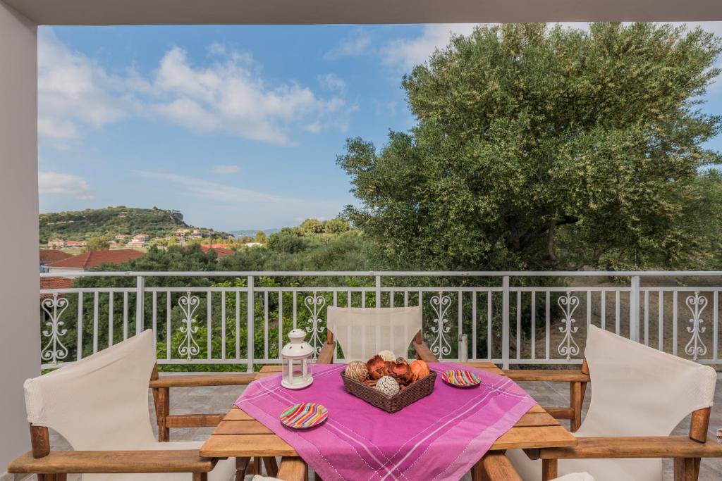 a table with a bowl of fruit on a balcony at Domus Lukas Apartments in Marathias