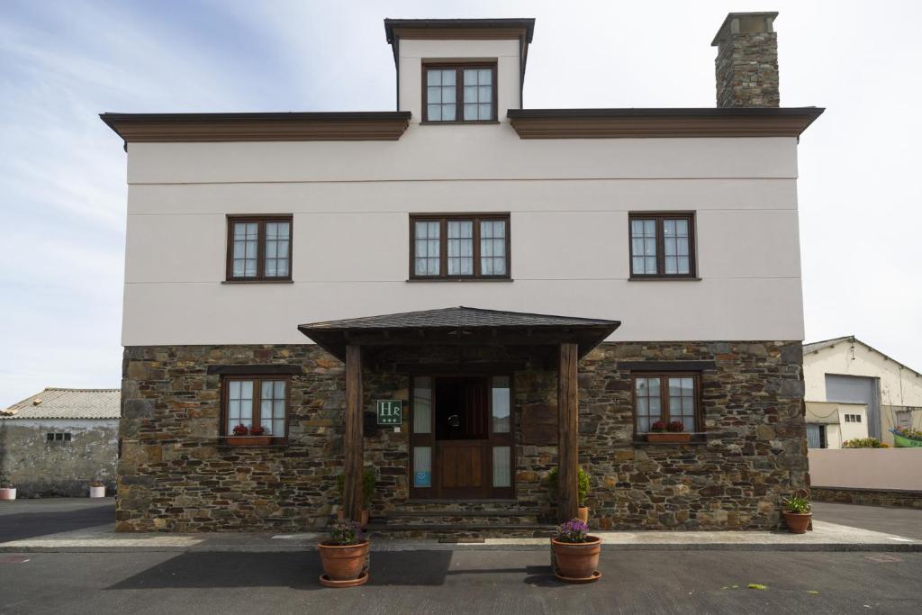 Casa blanca grande con un edificio de piedra en Hotel Rural As Laguas, en Tapia de Casariego
